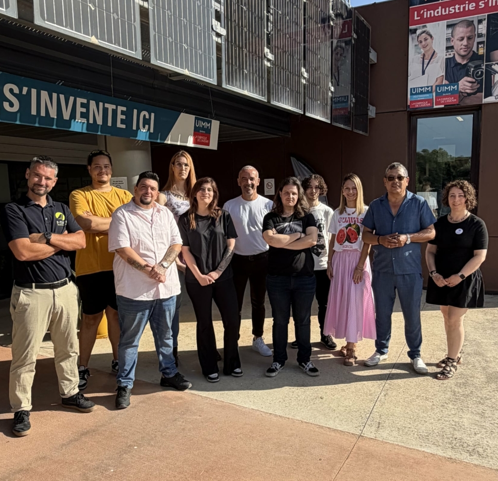 Group of people posing outside a building with solar panels on the facade, forming a team photo.